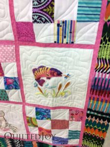 Embroidered fish on a baby quilt. Quilted at QuiltedJoy.com