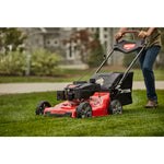 CRAFTSMAN M355 Self Propelled Lawn Mower close up in side view mowing lawn in green shirt and jeans