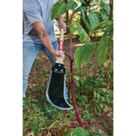 Wood handle weed and brush cutter being used to cut a plant.