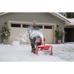 SELECT 26 inch 243 CC two stage gas snow blower with push button electric start being used by a person.