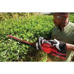 Cordless 24 inch hedge trimmer kit 2.5 Ampere hours being used to trim hedge top.