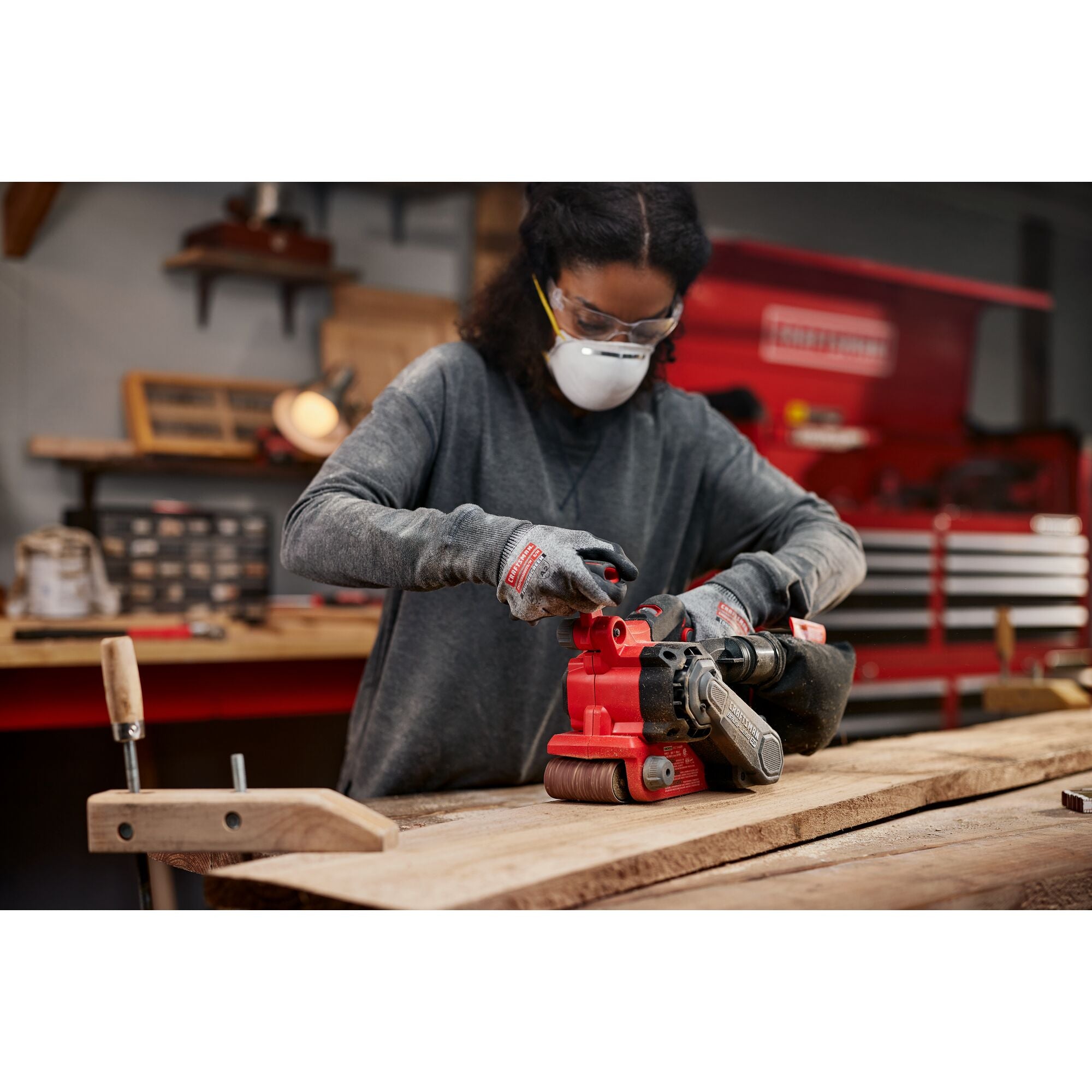 Woman using Craftsman Brushless RP Belt Sander on wood