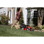 CRAFTSMAN 140cc Push Mower in side view mowing the backyard lawn with maroon shirt