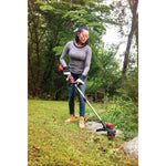 20 volt weedwacker 13 inch brushless cordless string trimmer with quickwind 4.0 ampere per hour being used by a person to trim grass outdoors.