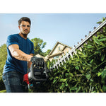 22 inch 2 cycle gas hedge trimmer being used by a person.