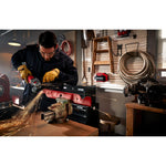 Cordless 4 and half inch small angle grinder kit 1 battery being used to cut hard material by person.