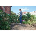 Wood handle cultivator being used by a person.