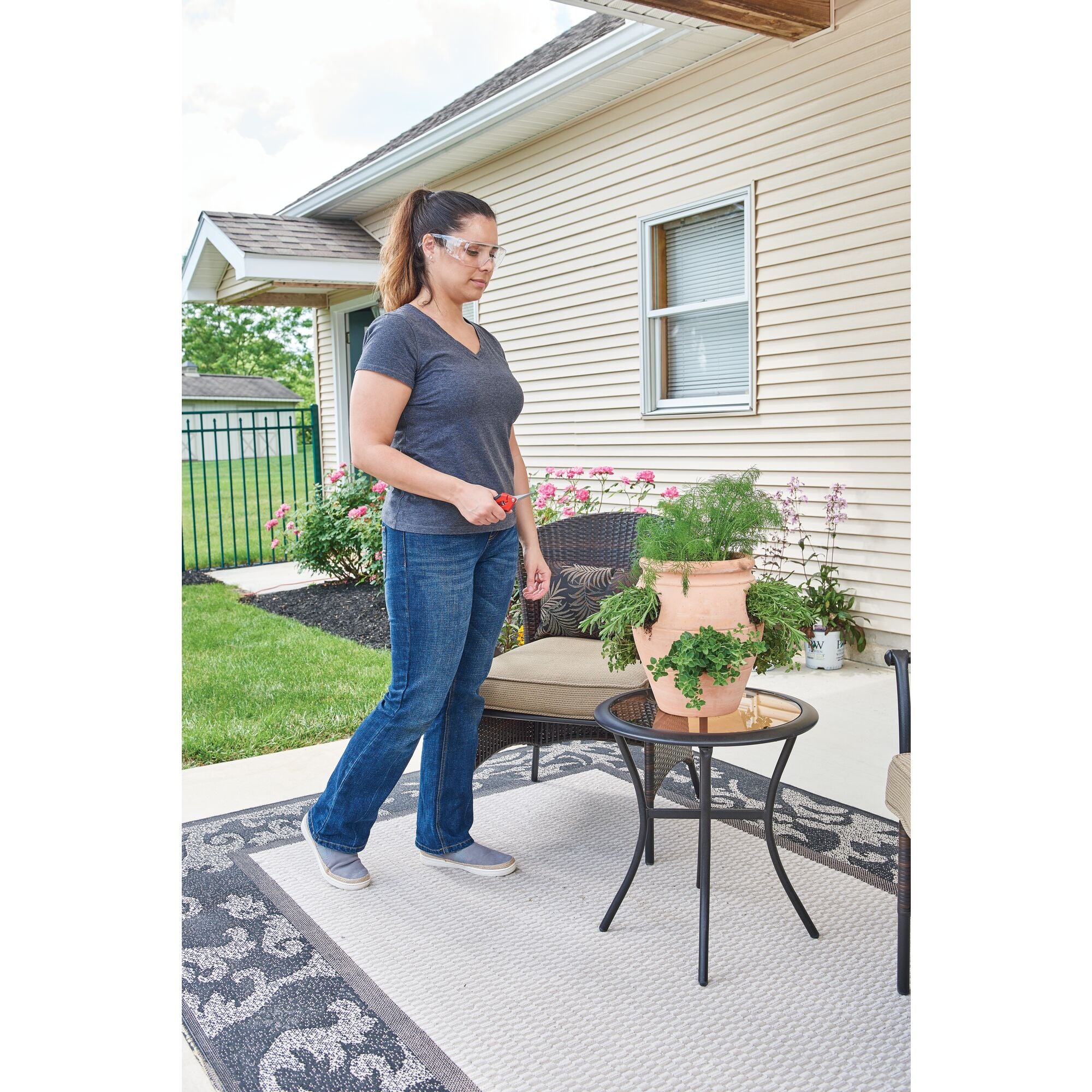 A person holding garden snips outdoors.