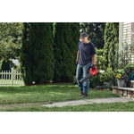 Cordless hard surface blower being used for blowing trimmed grass from sidewalk.