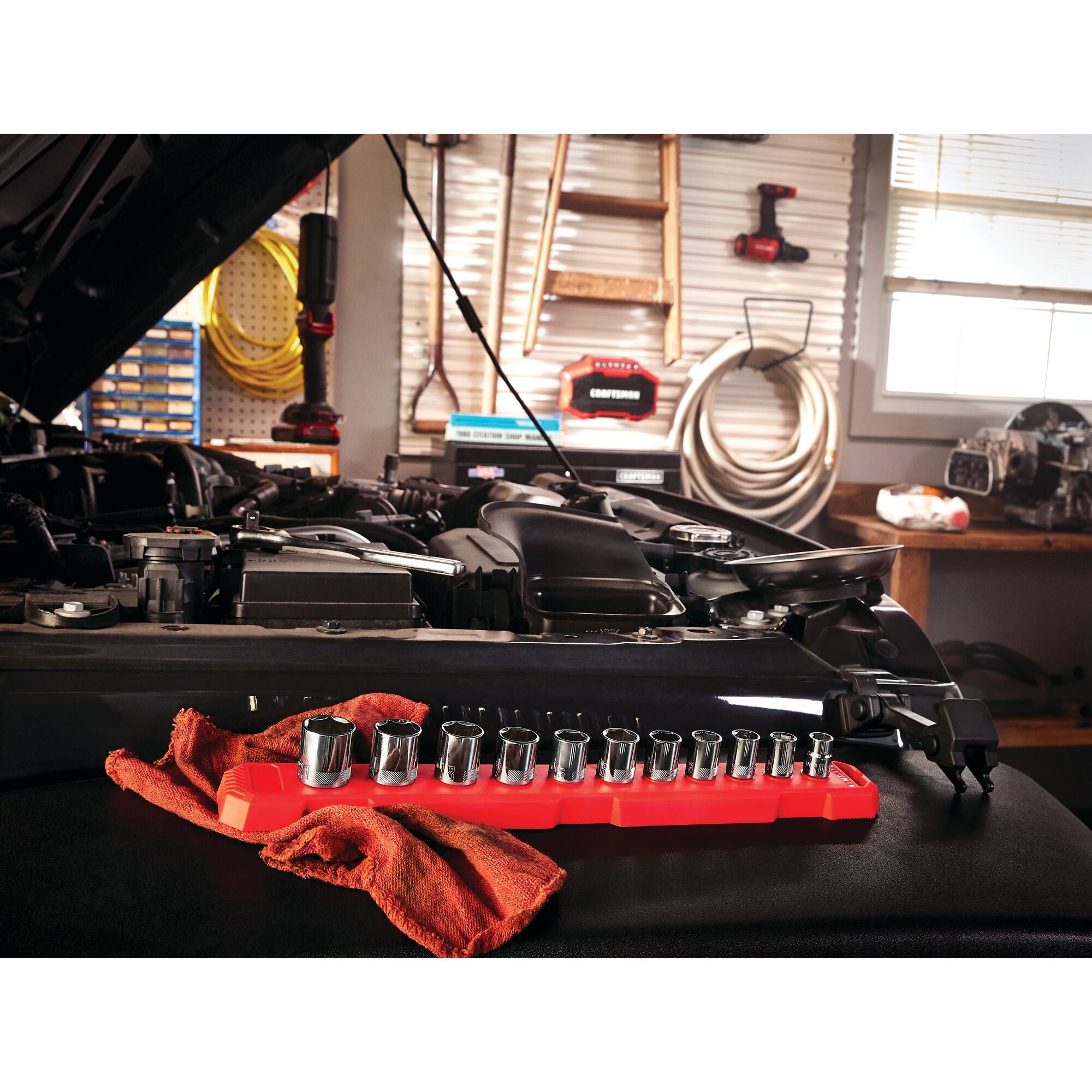 11 piece 3 eighths inch drive metric 6 point socket set placed near an open vehicle engine.