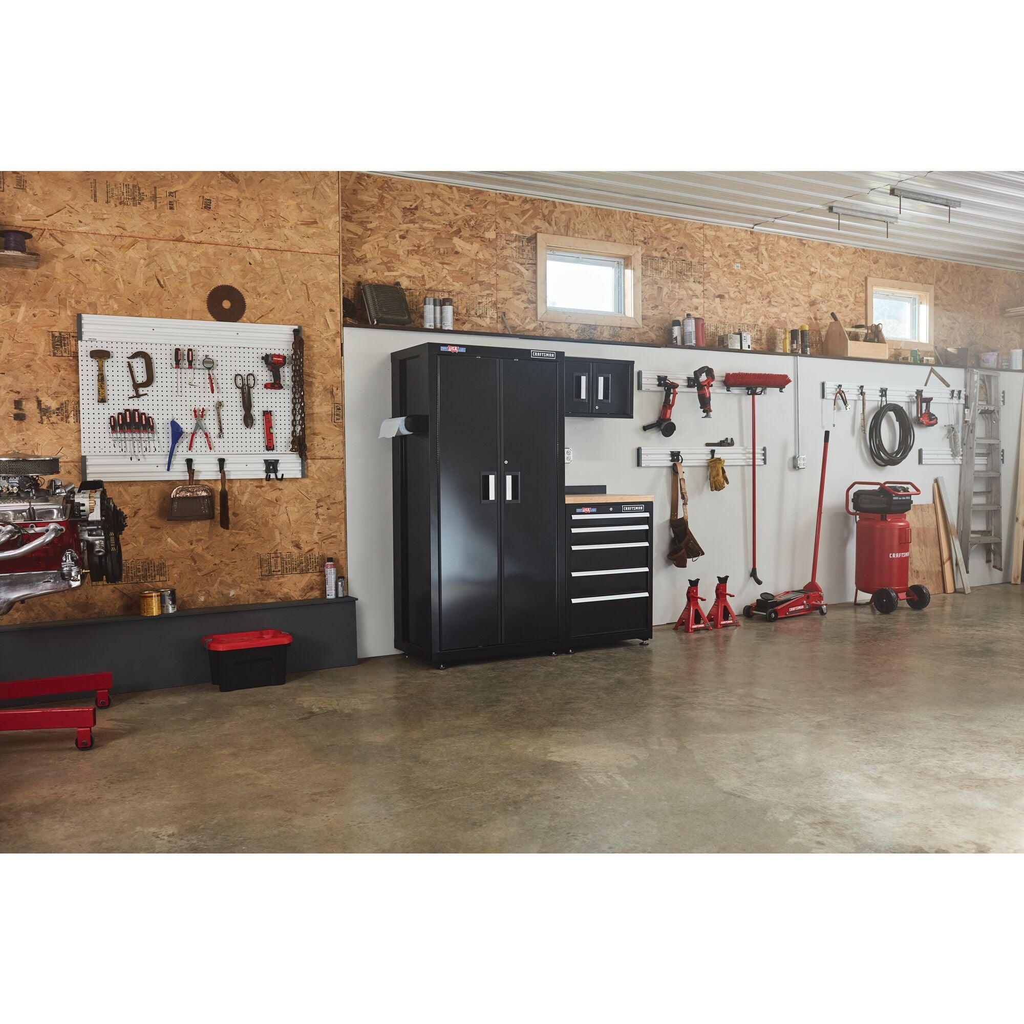 63 inch Wide 4 Piece Welded Metal Storage Suite With Drawer Storage placed in a garage workshop along with a variety of tools and other equipment.