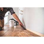 1.75 peak H P powerhead bucket head wet dry vacuum being used by a person to clean wooden floor.