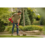 CRAFTSMAN SE2200 Gas Edger edging down sidewalk with flowerbed wearing jeans and green shirt