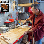 DIYer using long crevice tool with CRAFTSMAN shop vacuum to clean dust on top of workbench