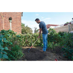 Wood handle garden hoe being used by a person.