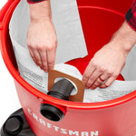 Top view of CRAFTSMAN 16-20 gallon dust collection bag installation on inlet inside vac drum