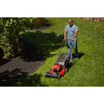 CRAFTSMAN M220 150cc 21-in. Self-propelled Gas Push Lawn Mower mowing around flower bed overhead view wearing jeans and blue shirt