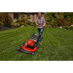 CRAFTSMAN M125 Push Mower mowing the grass in the backyard in front view in plaid shirt