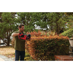 Cordless 22 inch hedge trimmer kit 2 ampere hours being used to level hedge.