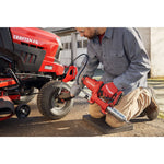 Photo of end-user applying grease with grease gun to farm equipment.