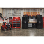 Man handing trimmer on versatrack with garage filled with power tools, storage, outdoor products