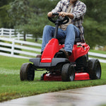 30 inch 10 h p gear drive mini riding mower with mulching kit being used to mow a lawn.