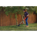 20 volt weedwacker 13 inch cordless string trimmer and edger with automatic feed kit being used by a person to trim weeds outdoors.