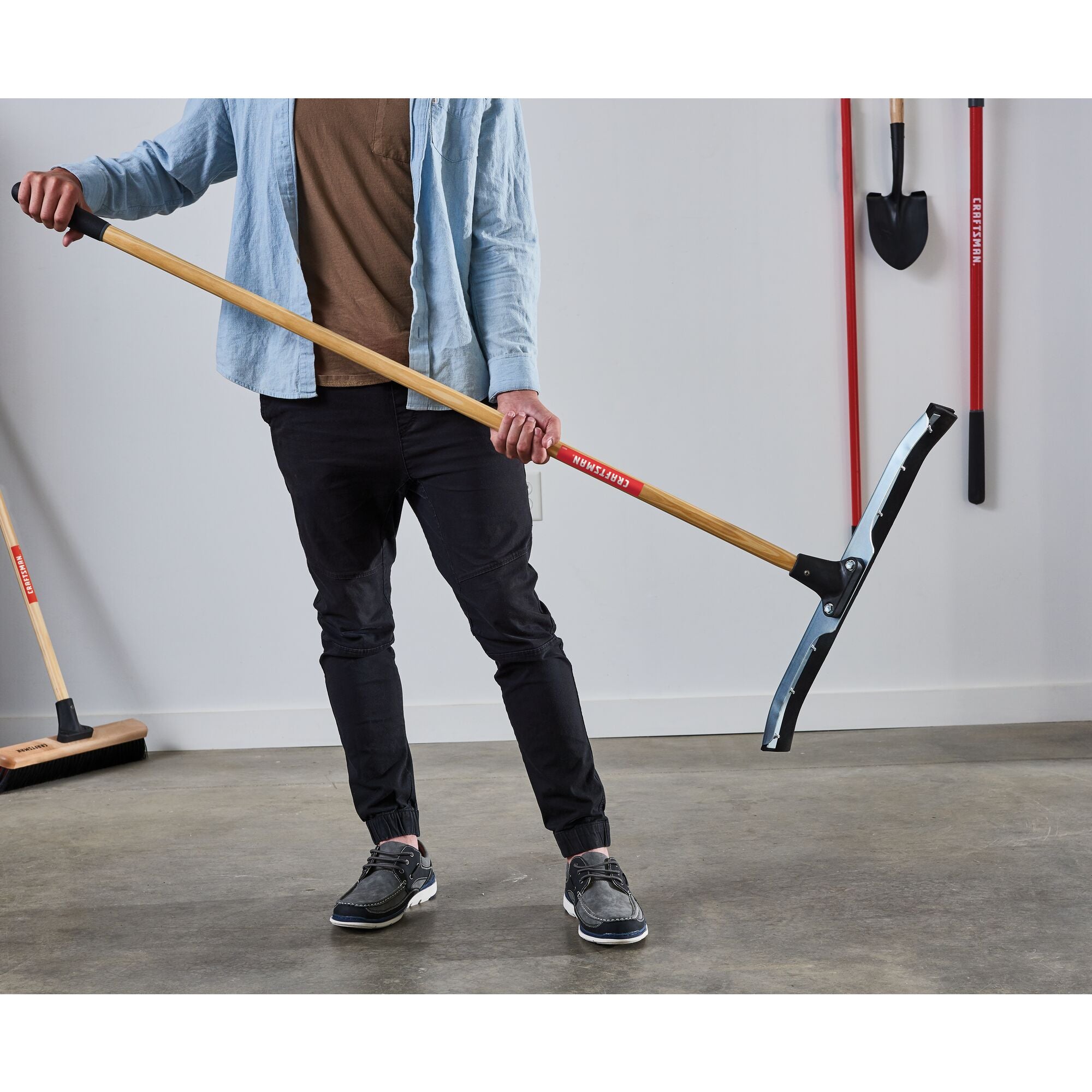 24 inch dual-blade floor squeegee in a garage with shovels and brooms