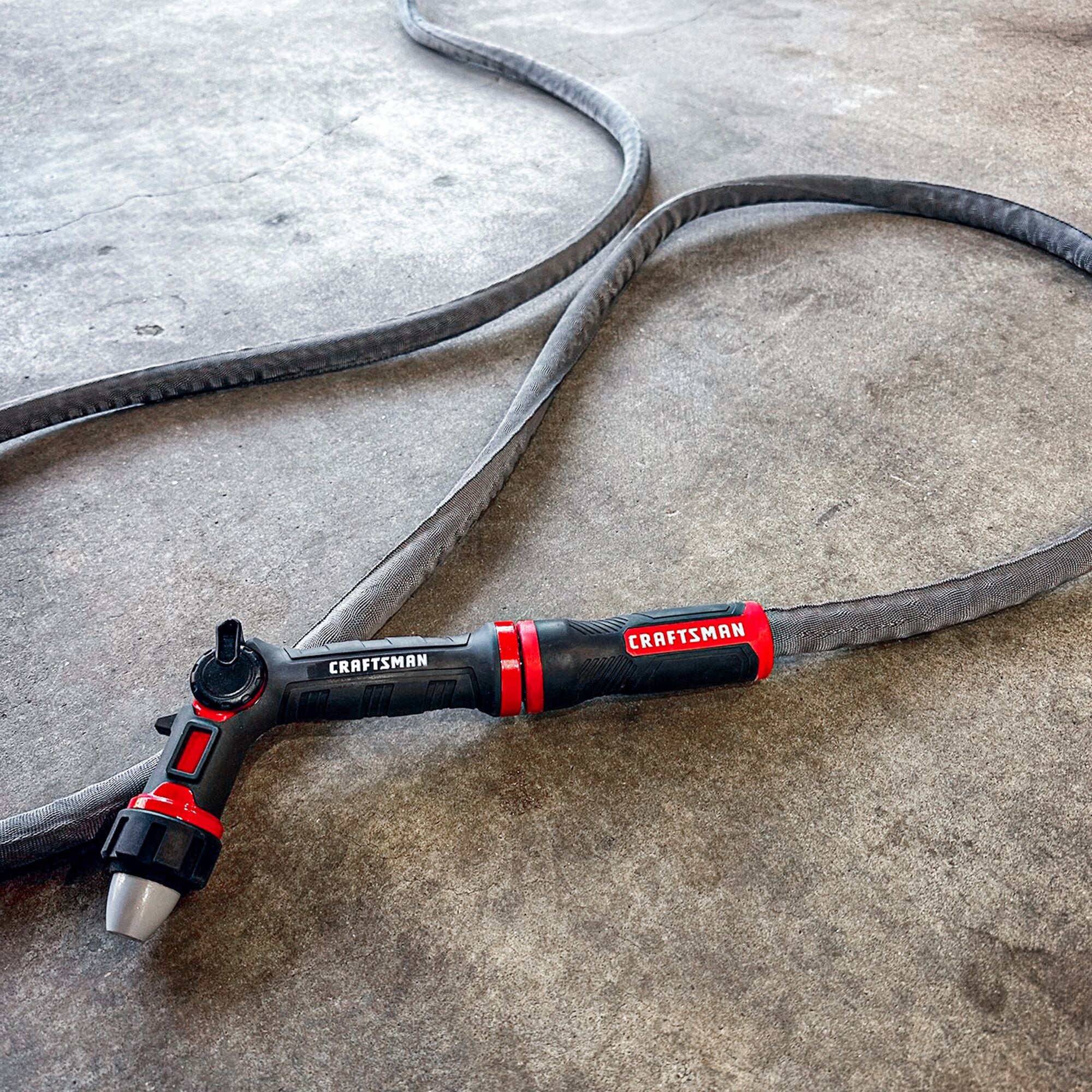 Black and red craftsman heavy-duty fabric hose, 50-foot by 5/8 inch. Displayed with a water nozzle connected to the end.