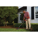 20 volt weedwacker 13 inch brushless cordless string trimmer with quickwind 4.0 ampere per hour being used by a person to trim grass outdoors.