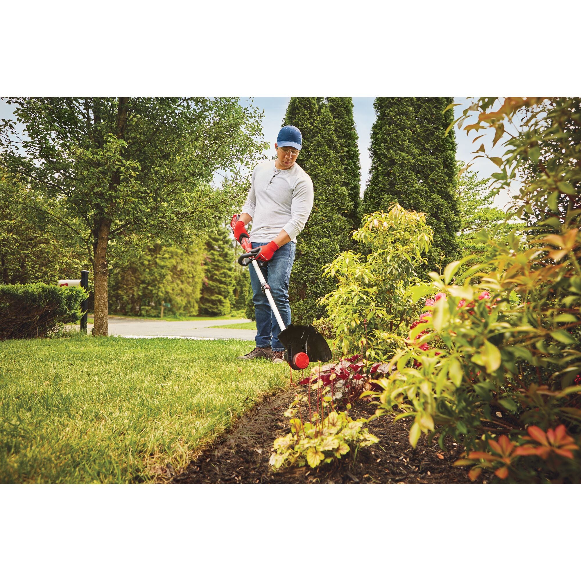 20 volt cordless 13 inch weedwacker string trimmer edger with push button feed being used by a person to trim grass outdoors.