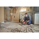 Man with gloves, respirator and safety glasses using the CRAFSTMAN V20 Brushless RP 7/8 inch SDS plus Rotary Hammer with to remove tile flooring.