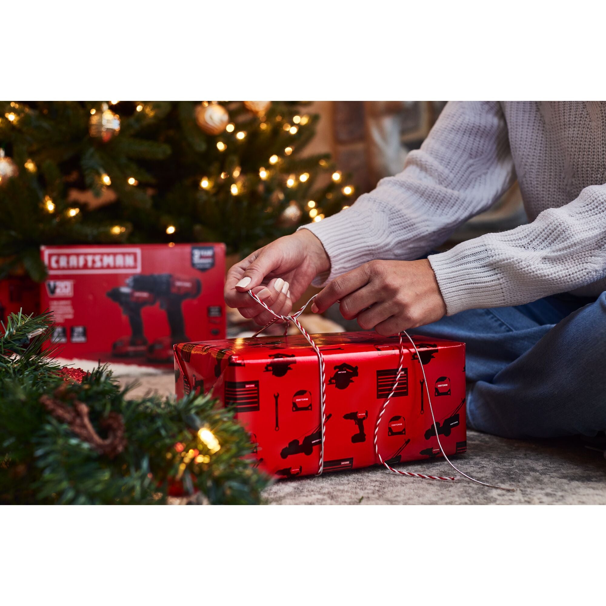 Female hands wrapping gift in CRAFTSMAN wrapping paper