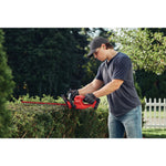 Cordless 20 inch hedge trimmer being used to level hedge by person.