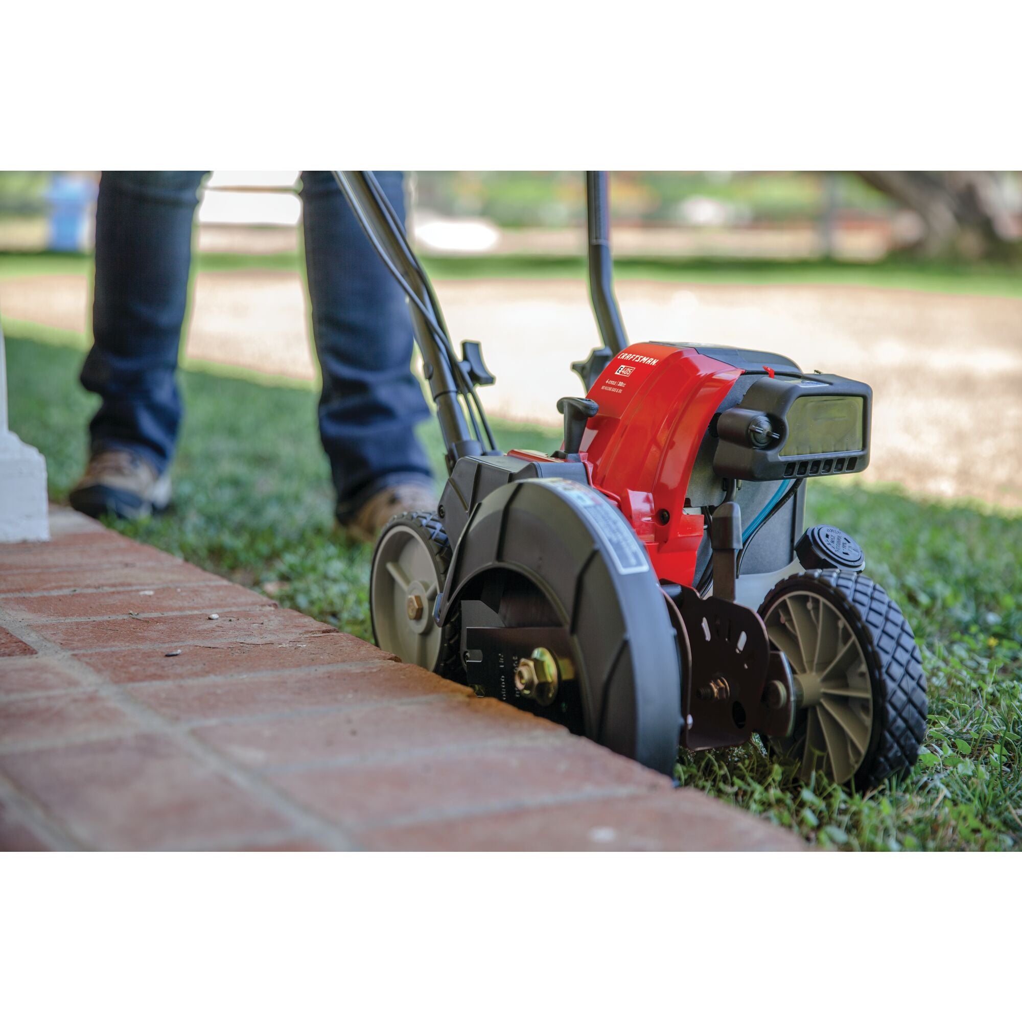 CRAFTSMAN 4 Cycle Gas Edger edging tile patio in side view with jeans and boots