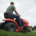 42 inch 17.5 h p gear drive riding mower being used by a person to mow the lawn.