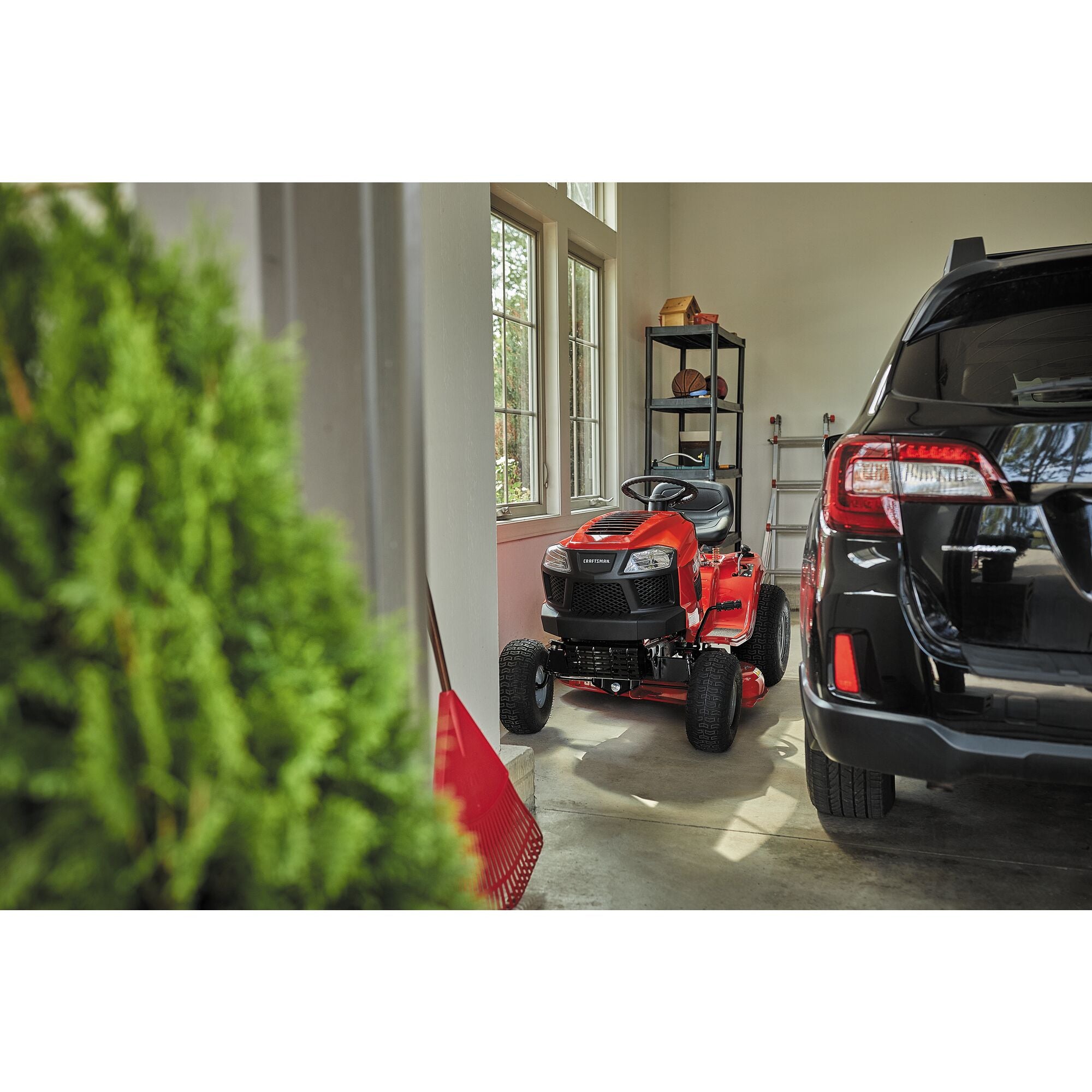 Riding mower with mulching kit placed in garage.