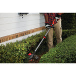 20 volt weedwacker 13 inch brushless cordless string trimmer with quickwind 4.0 ampere per hour being used by a person to trim bushes outdoors.