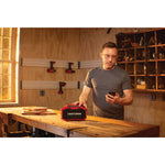 20 volt cordless bluetooth speaker being used by a person in a work shop indoors.