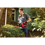 Cordless 22 inch hedge trimmer kit 2 ampere hours being used to level bushes sides.