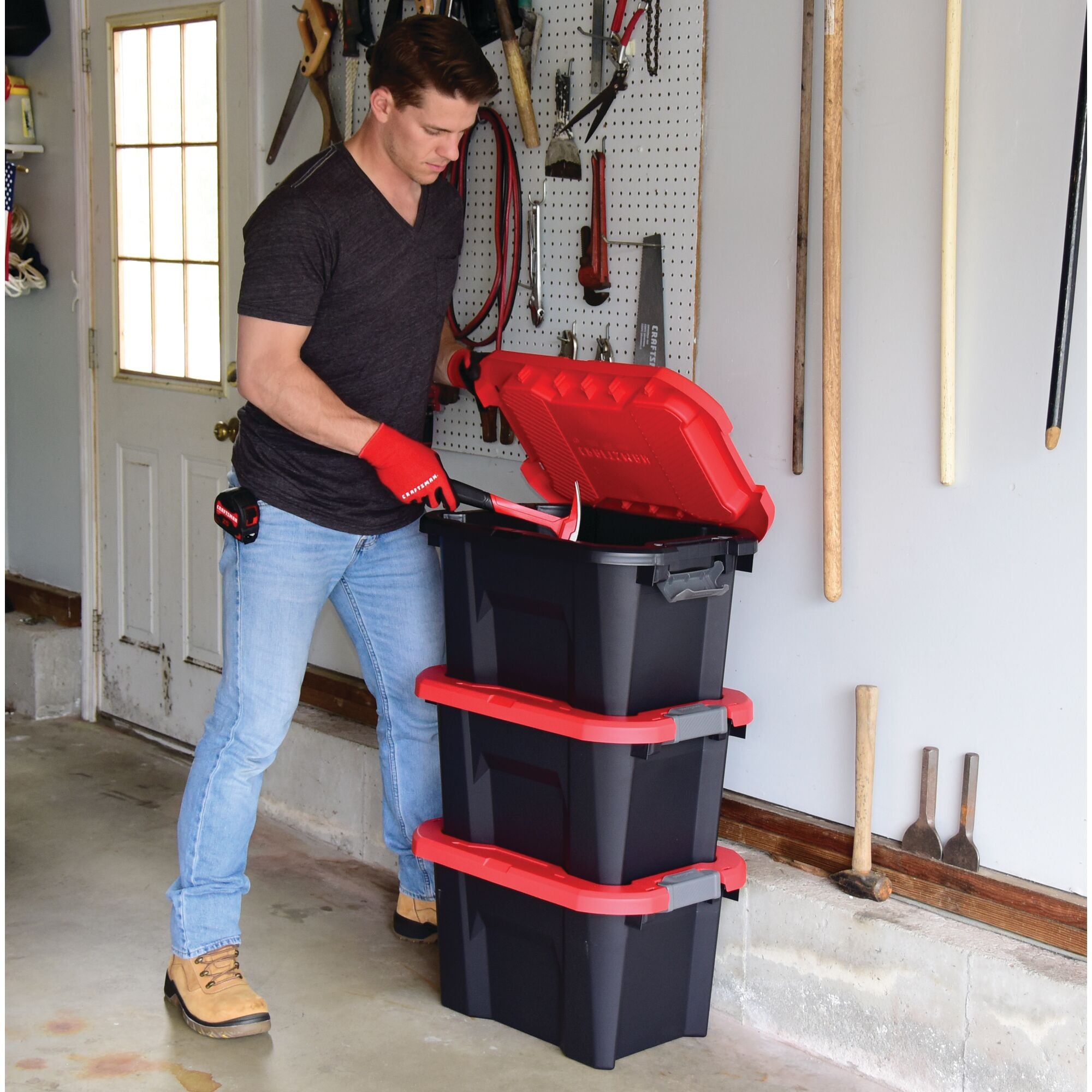 10 Gallon latching tote being used by a person to store tools.