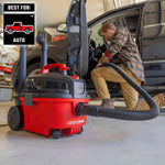Man kneeled down cleaning out car in garage with CRAFTSMAN 4 Gallon wet dry shop vacuum and hose