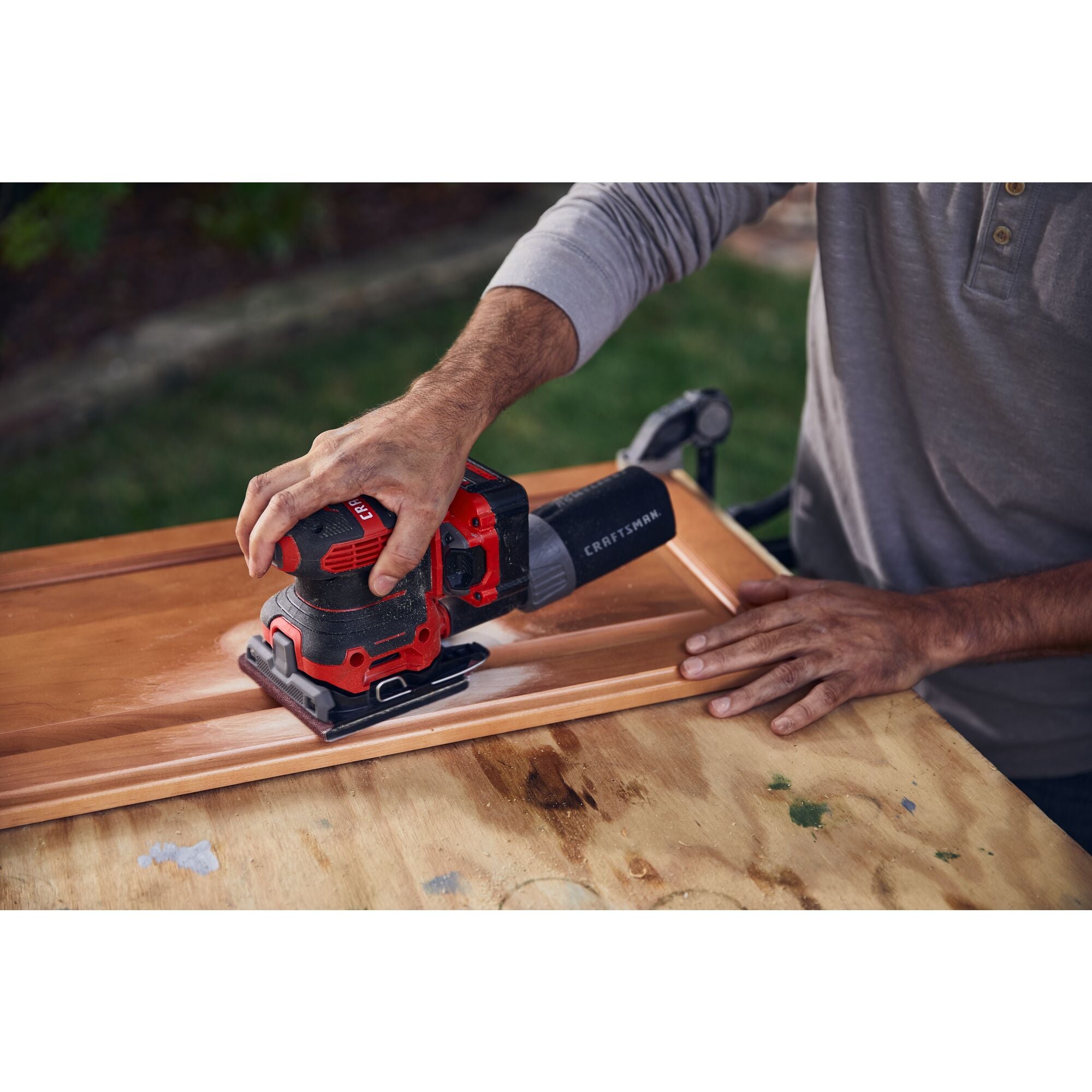 20 volt cordless quarter sheet sander in use.