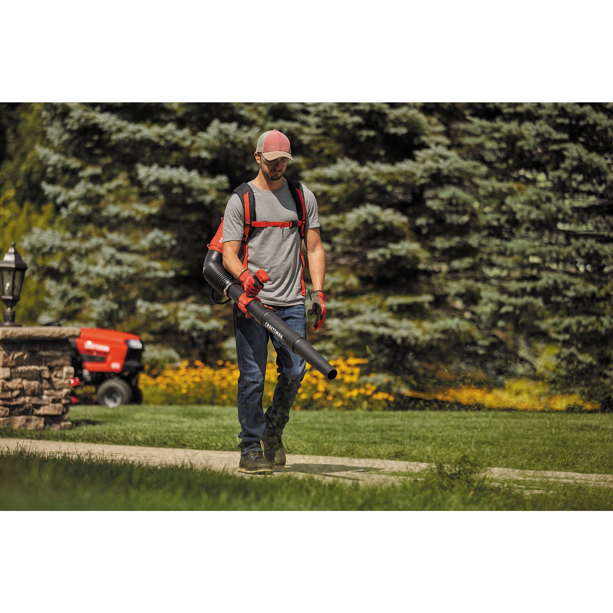 51 C C 2 cycle gas backpack leaf blower being used by a person to clean outdoor area.