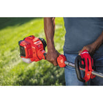 Weedwacker 27 C C 2 cycle 18 inch attachment capable straight shaft gas trimmer being carried by a person.