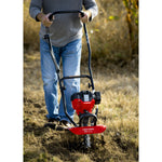 CRAFTSMAN gas cultivator in front view cultivating field in jeans and gray shirt