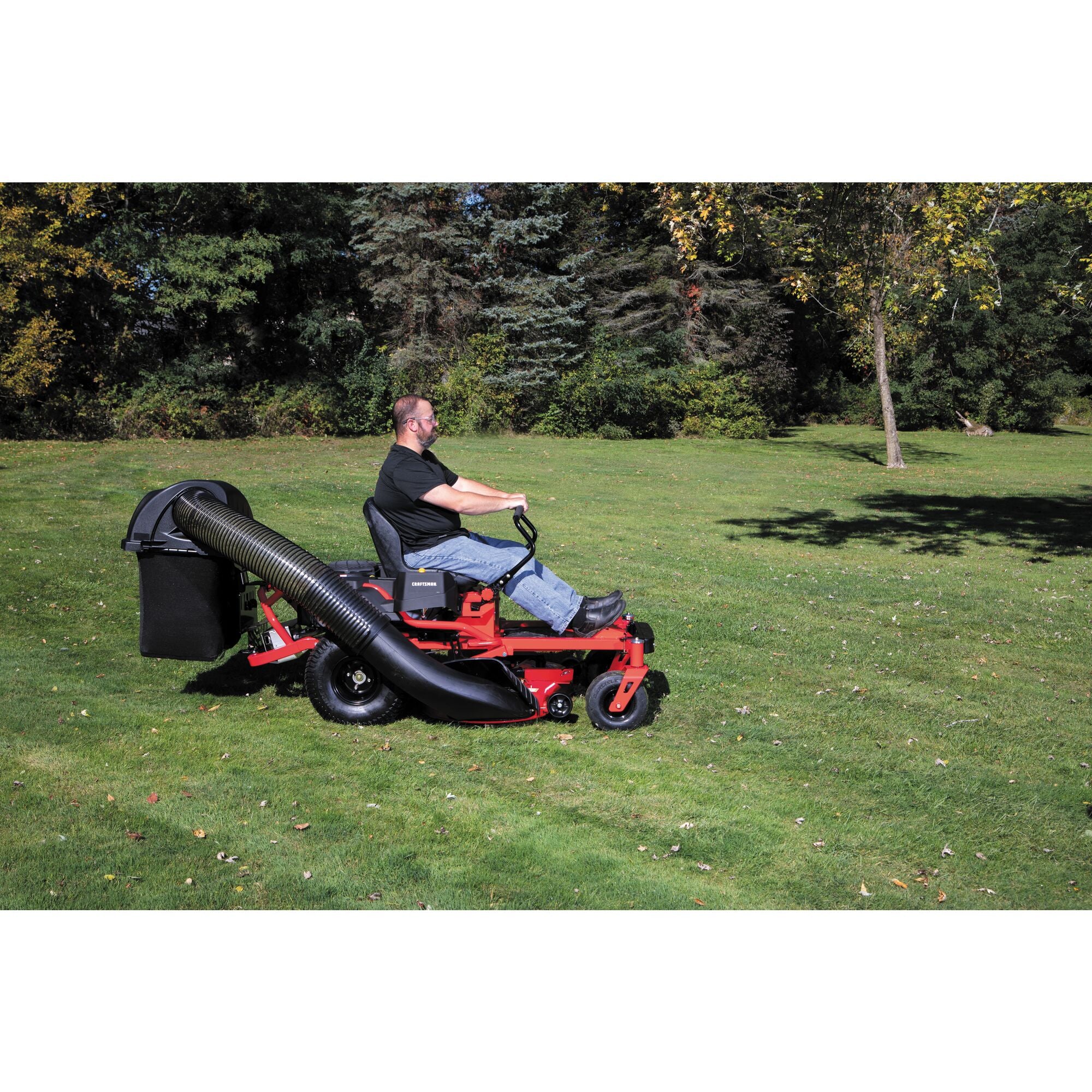 42 inch and 46 inch zero turn double bagger being used to cut grass by person.