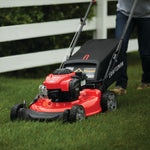 Side view of male cutting front of house grass with M110 Walk-behind Lawn Mower