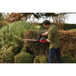Cordless 24 inch hedge trimmer kit 2.5 Ampere hours being used to level sides of hedge.