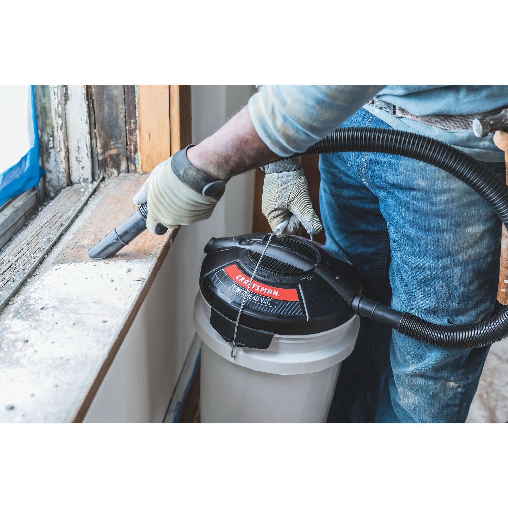 1.75 peak H P powerhead bucket head wet dry vacuum being used by a person to clean window frame.